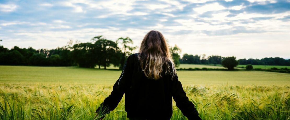 Woman standing in barley field