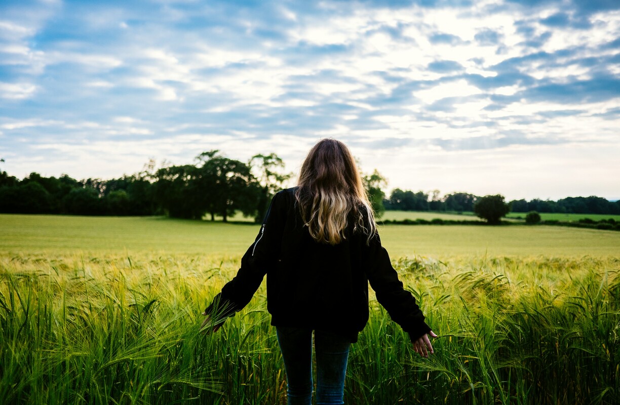 Woman standing in barley field